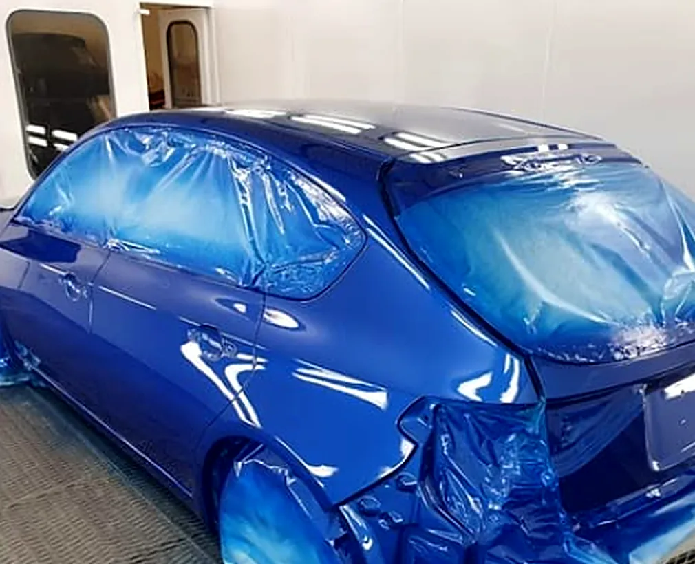 Voiture fraîchement peinte en cabine à l'atelier